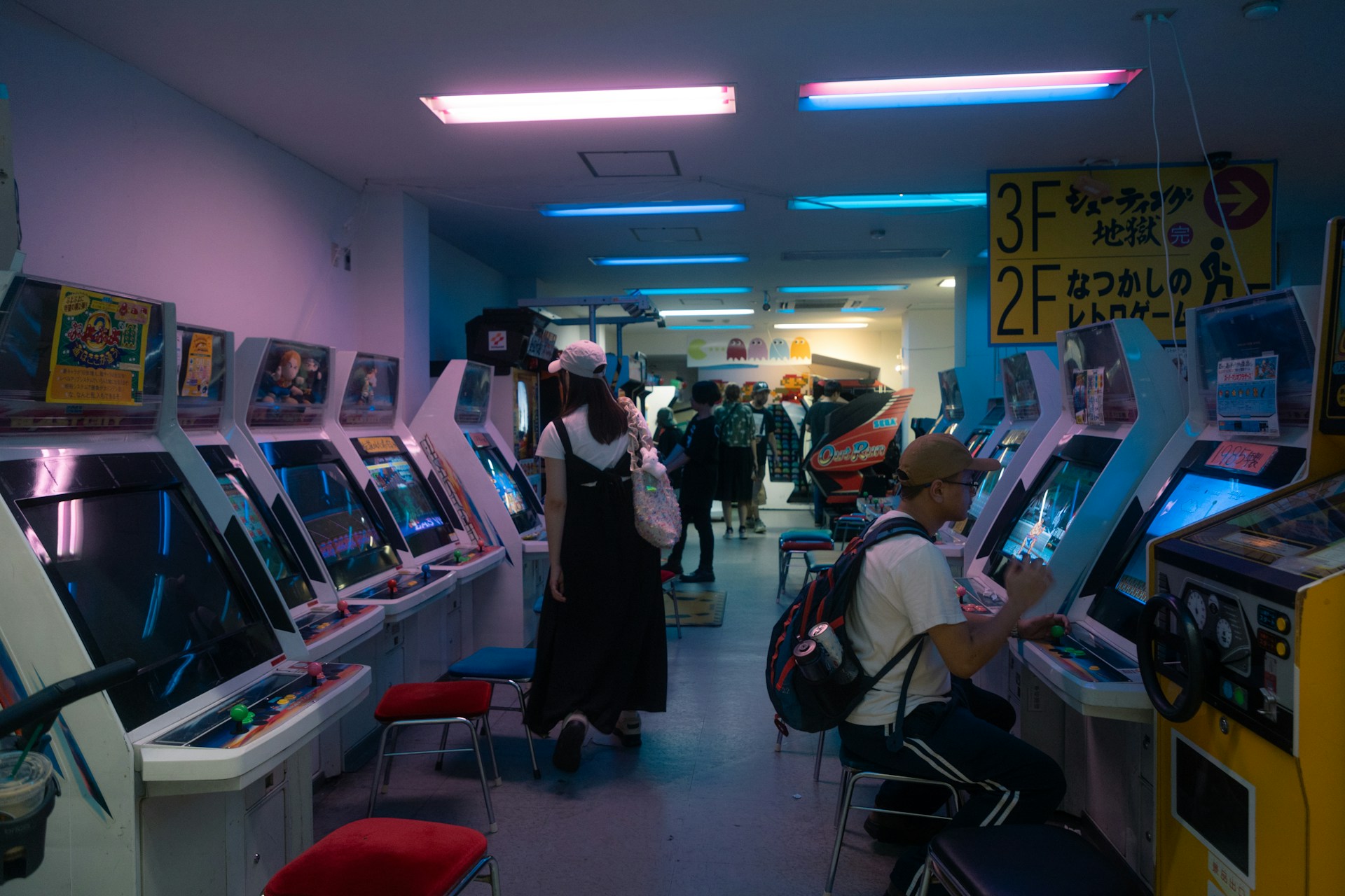Salle de jeux d'arcade éclairée de néons roses et bleus