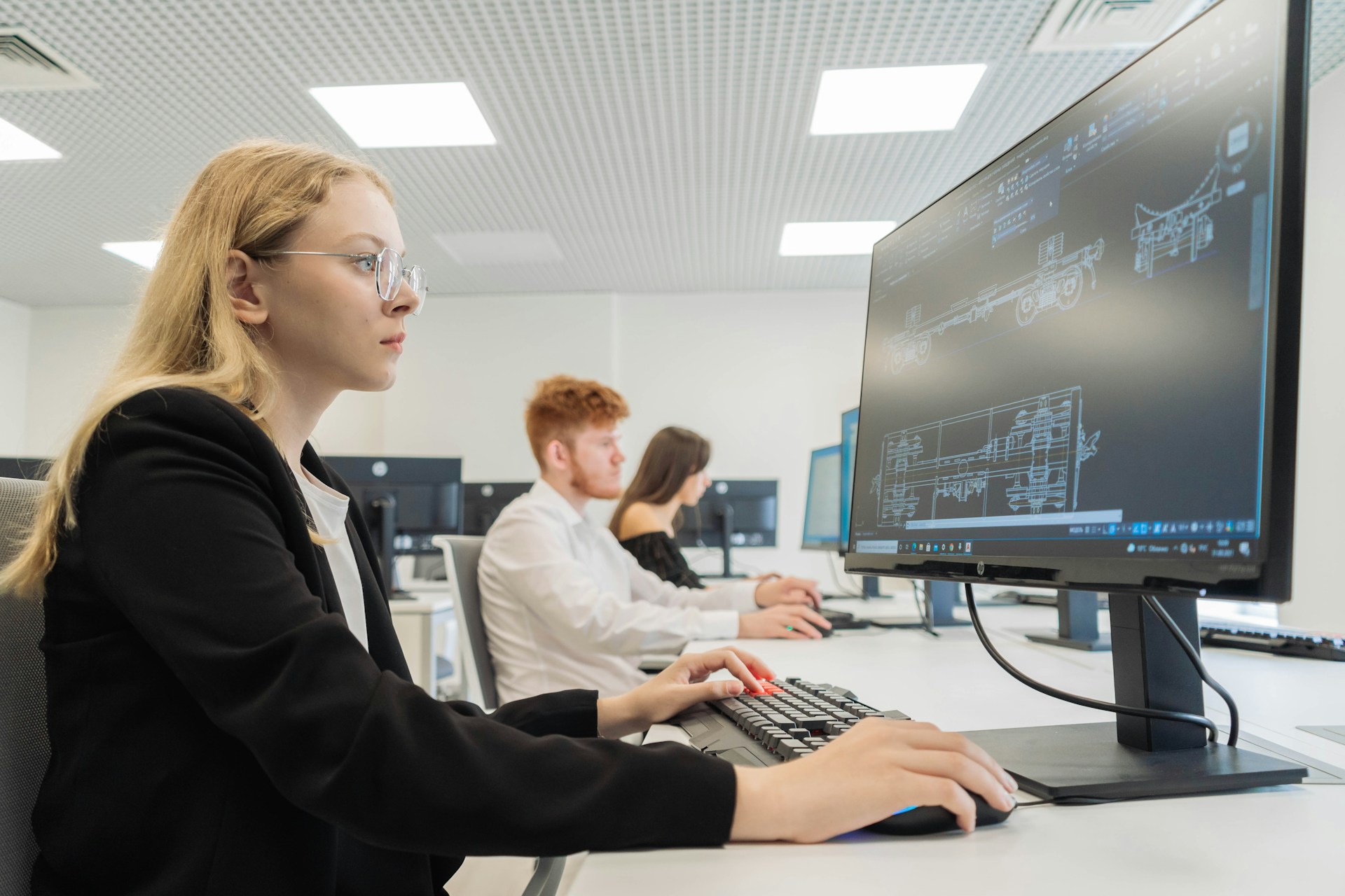 Étudiante concentrée devant un écran de conception technique